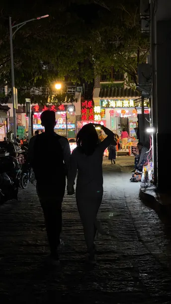 一个男子和一个女子在夜晚走一条黑暗的街道