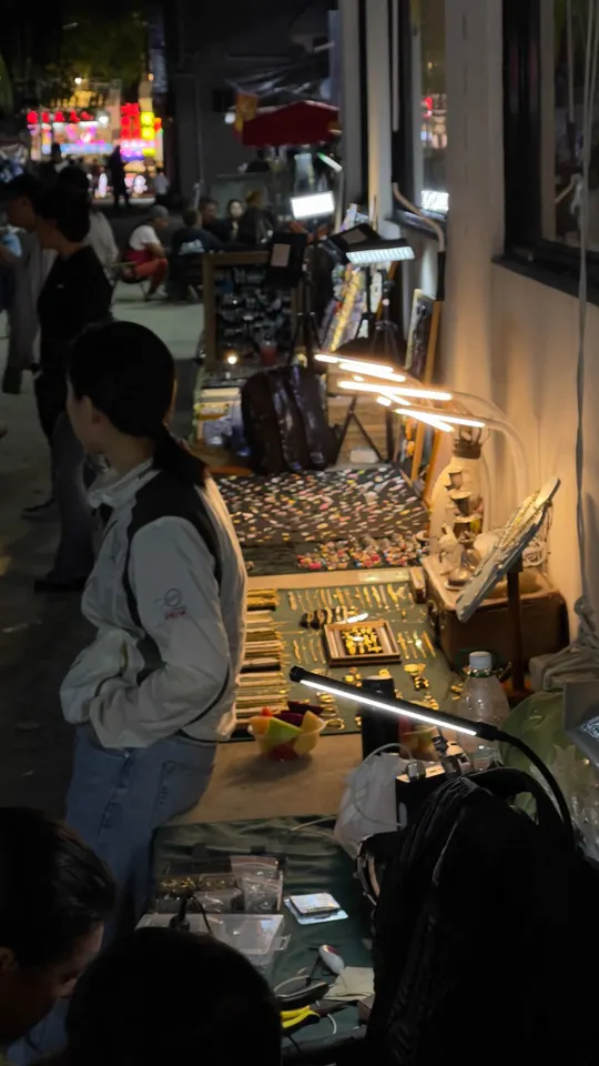 站在夜市桌子旁边的一个男人