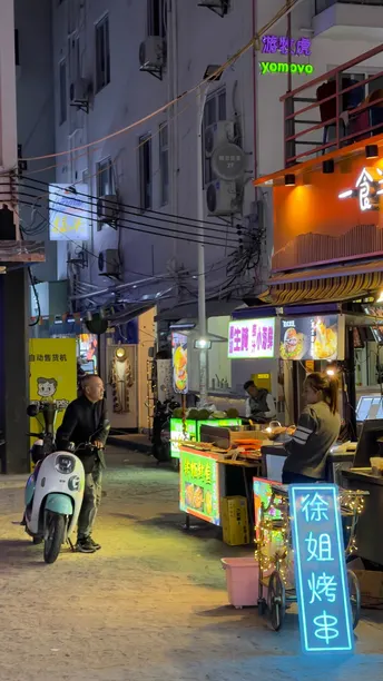 夜晚街道上有人骑滑板车和摩托车