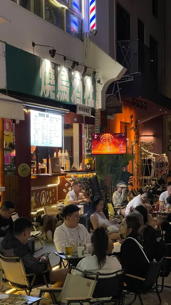 很多人晚上坐在餐厅外面的桌子旁