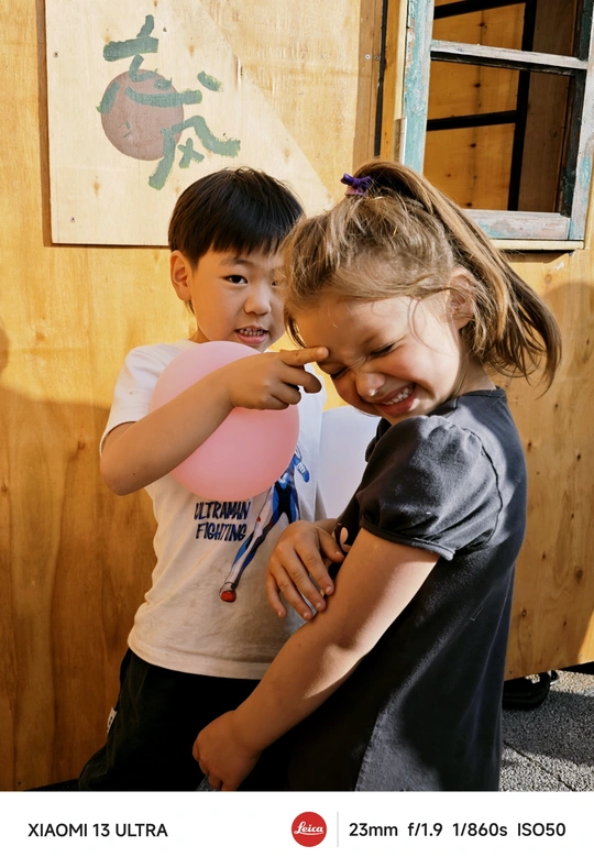 一个小男孩拥抱着一个拿着气球的女孩