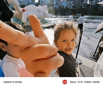 一个小男孩在水中伸出他的手 一个小女孩用手指指着相机。