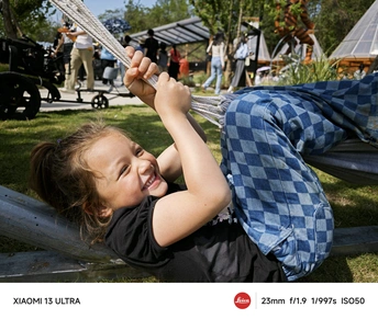 一个小男孩在公园的草地上躺着 一个年轻女孩微笑着。
