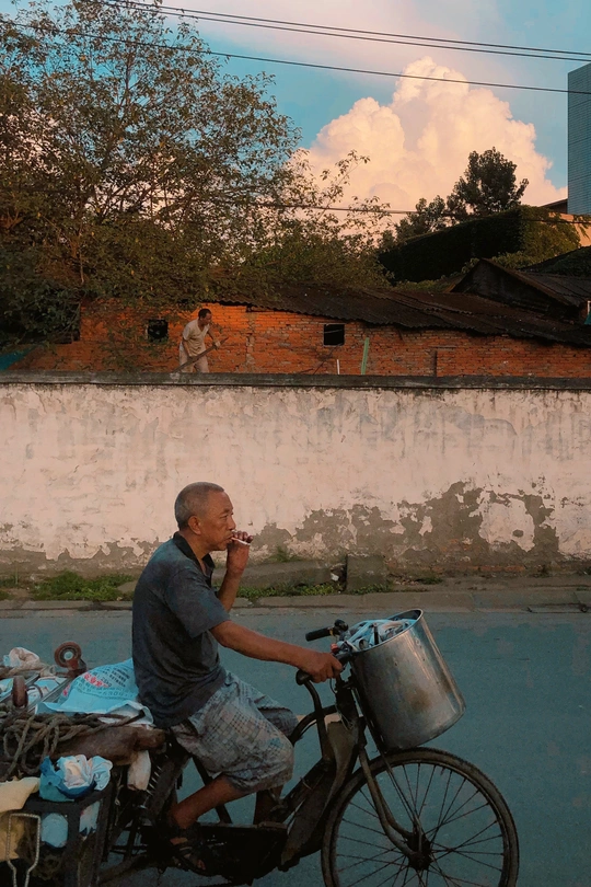 一个坐在自行车上的男人在街上吃饭