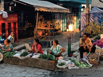 妇女在市场附近的街上卖水果和蔬菜