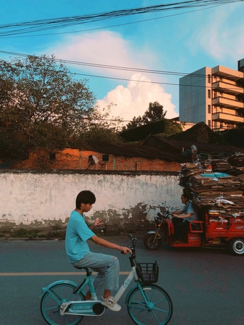 一个年轻人骑着一辆蓝色自行车沿街而行