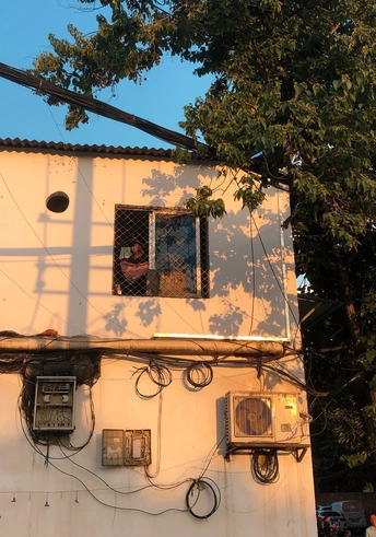 一个男人从一栋旧建筑的窗户向外看