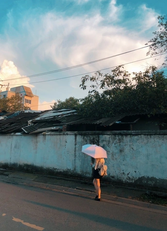 一个撑着白伞的女人走在街上