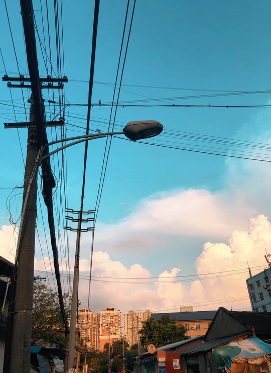 有电线、建筑物、汽车和蓝天的城市街道