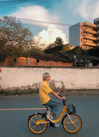 一个骑着黄色自行车在街上的老人