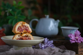 桌子上放着一小盘食物 旁边放着一个杯子和一些花
