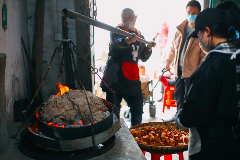 一个男人在街上用火做饭 正在烤鸡。