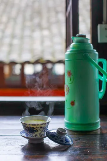 一个绿色的壶和一杯热茶在桌子上