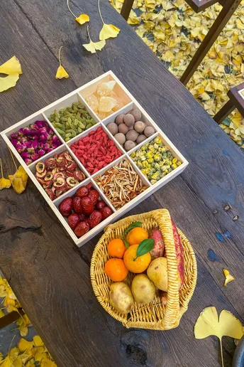 一个木制桌子 上面放着一个托盘 里面装有水果和蔬菜。