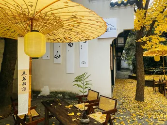 带有黄色遮阳伞的桌子椅子所在的庭院