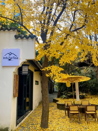 一个小餐厅 有桌子、椅子 还有黄色的遮阳伞。