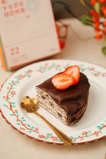 一个小巧的巧克力草莓甜点 放在盘子上 配一把叉子。