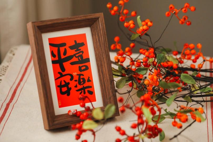 一张带有红色花朵和浆果的床 放在木制框架中。