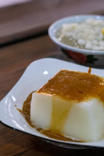 一个白盘子顶部放着甜点 旁边是一碗米饭。