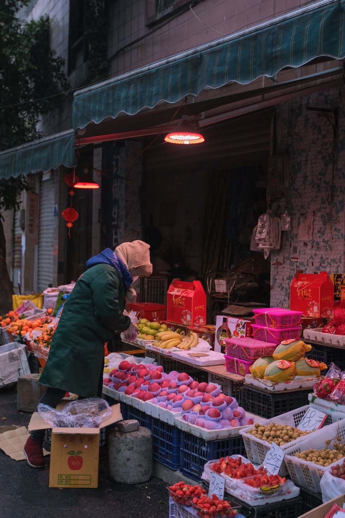 一位男士和女士在水果摊附近街道上 摊位上有水果和蔬菜。