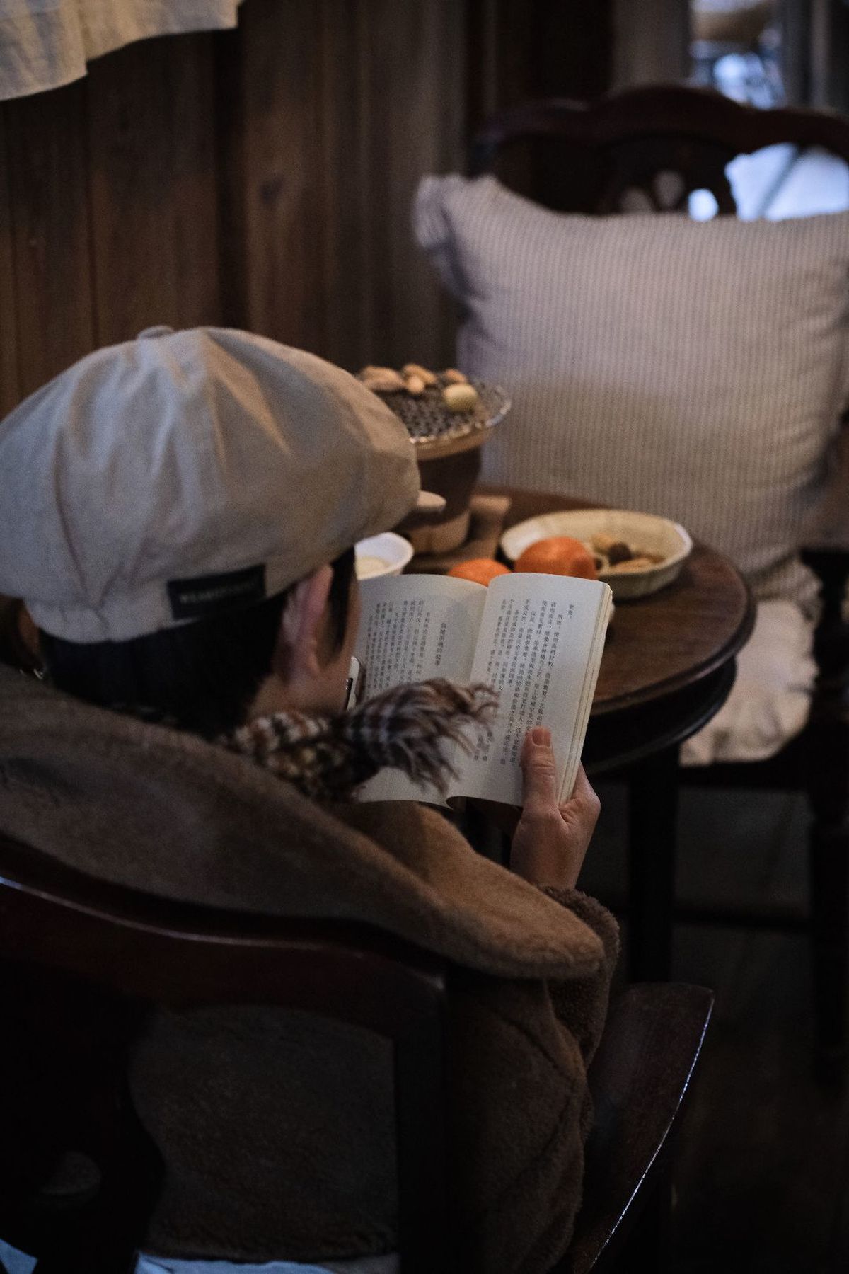 一个人枕着书在阅读 背景中有一位躺在床上的女人。