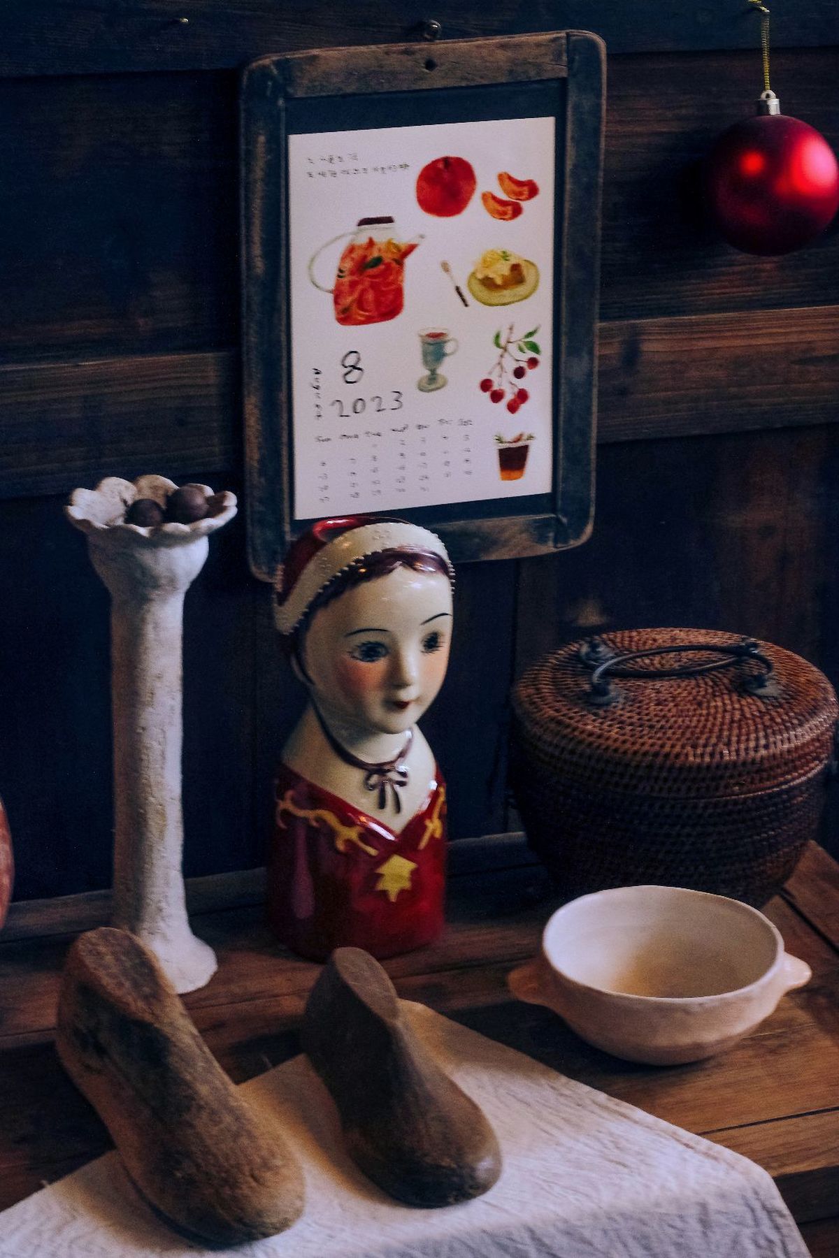 桌子旁边有一个木制洋娃娃和一盆苹果