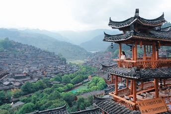 山顶上的一个佛塔 俯瞰着一个城市和山谷 背景是山脉。