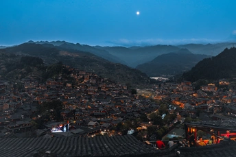 傍晚时分 村庄和山脉的夜景 被满月照亮的山谷。