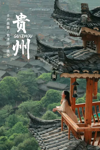 一位女性坐在阳台上 俯瞰着一座大城市 上面有一座塔。