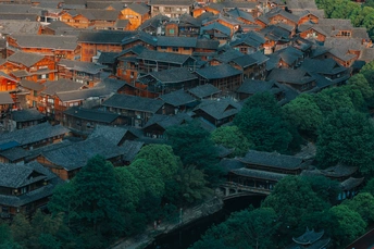 夕阳下城市的 aerial view 前景有房屋和河流。