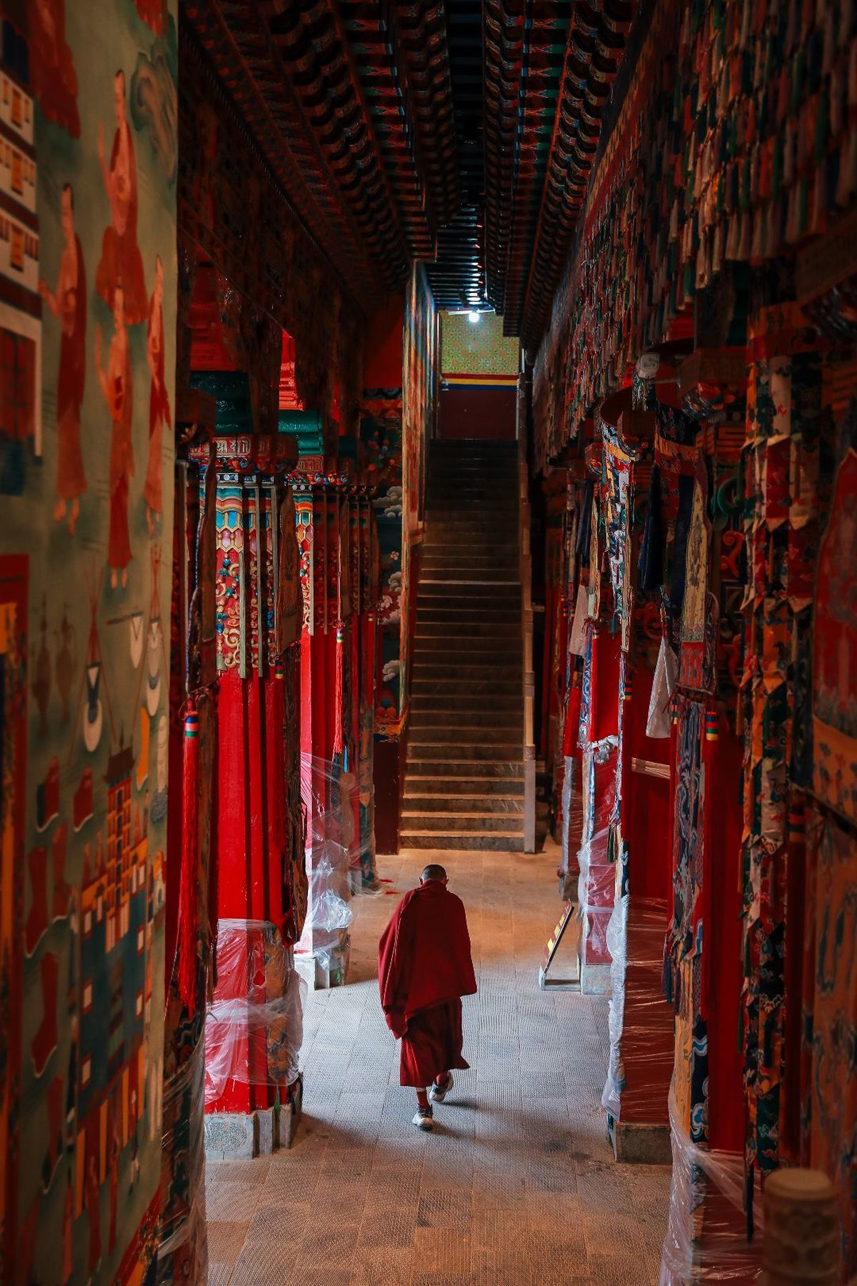 一个人穿着红袍在寺庙的走廊里走