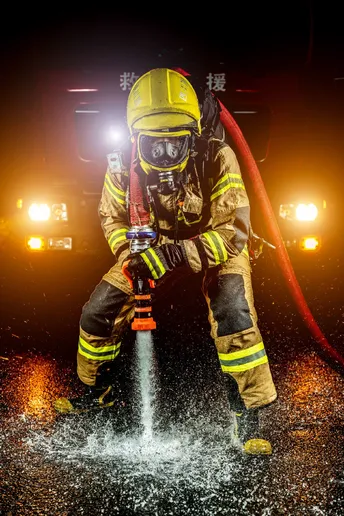 一名消防员使用水管扑灭火灾