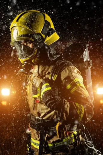 一位穿着装备的消防员在雪夜中站立