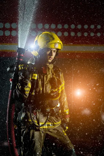 一名消防员站在火前