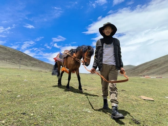 草原上牵马的少年