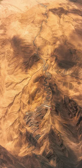 一架飞机在沙漠上空飞行 远处有山脉。