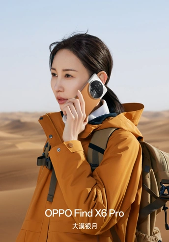 一位穿着外套和背包的女人在沙漠中打电话