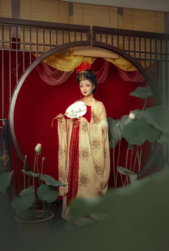 一个穿着红色连衣裙的年轻女子站在大门前