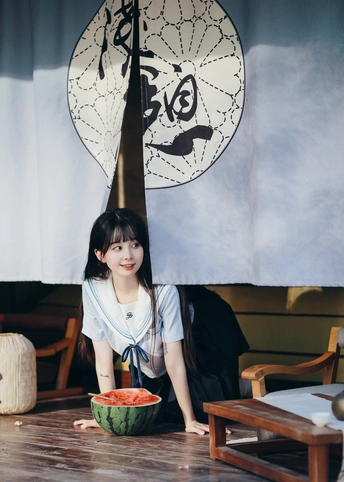 一个拿着一碗水果坐在桌子旁的年轻女人