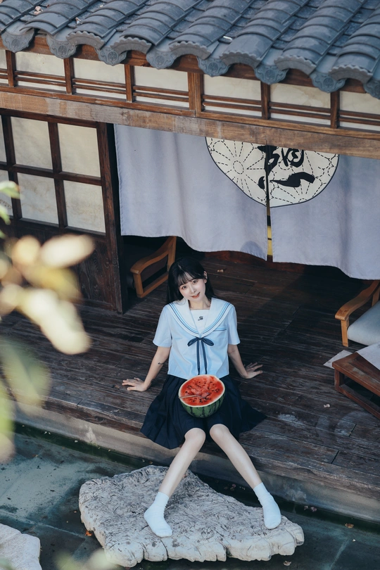 一个拿着一碗西瓜的年轻女孩