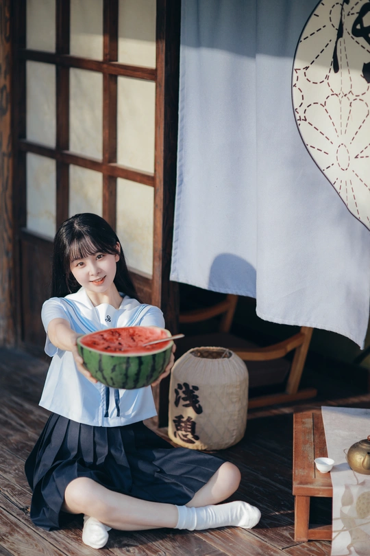 一个小女孩在地板上拿着一碗西瓜