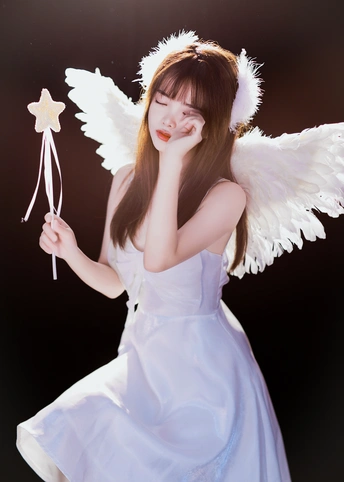 一个穿着白色连衣裙 翅膀上 holding a star 的年轻女孩
