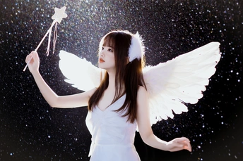 一位穿着白色连衣裙 翅膀上 holding a star 的年轻女子