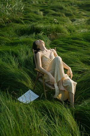 一个坐在草丛中的椅子上的女人
