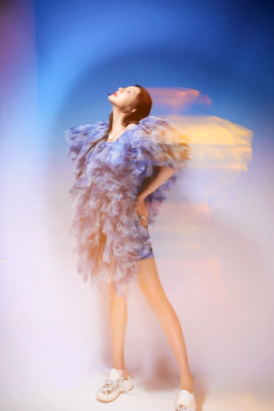 一位穿着紫色裙子的女士 背景中有白云