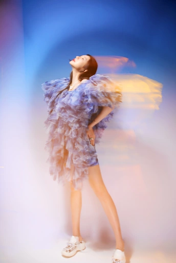 一位穿着紫色裙子的女士 背景中有白云