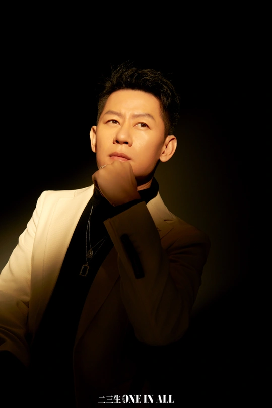 一个穿着黑色西装和领带的年轻人正在为拍照摆姿势。