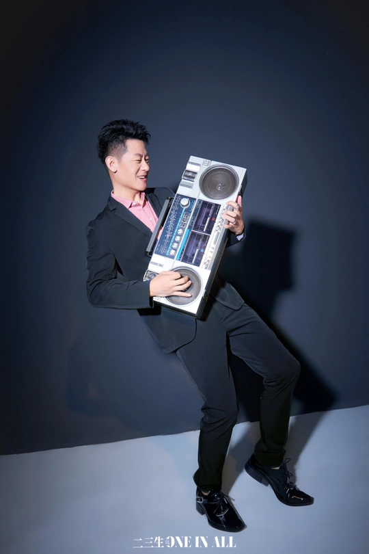 一个穿西装的男人拿着一个便携式音响