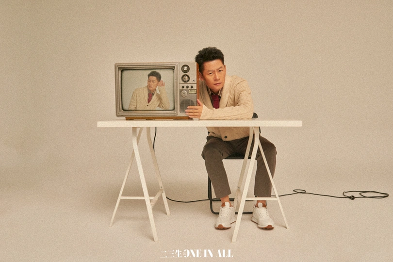 一个坐在小桌子旁边的小电视上的人