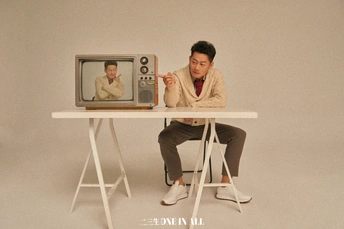 一个人坐在一个小桌子上 桌子上有一张电视的图片。